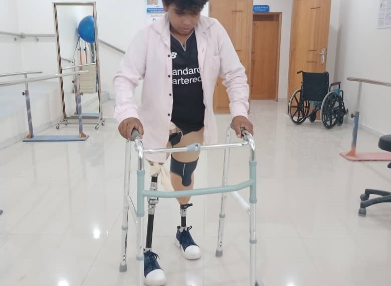 Hussein, âgé de 13 ans, a eu les deux jambes déchirées par une mine. HI l'aide à remarcher